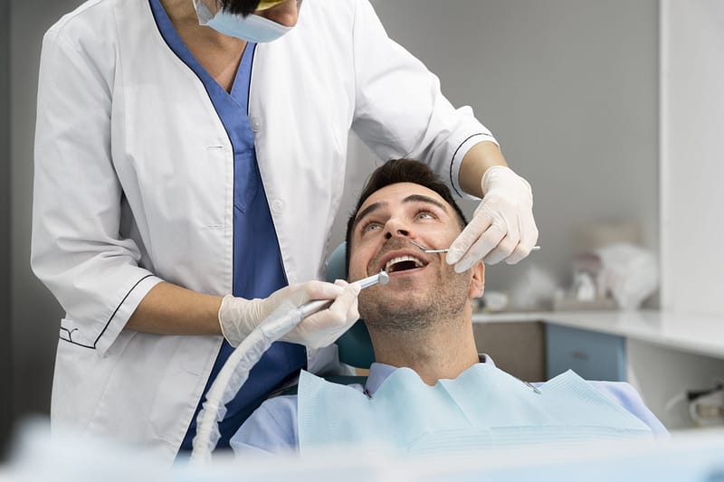 uomo esegue otturazione dente nel nostro studio dentistico di Desio